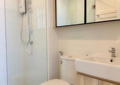 Modern bathroom with glass shower enclosure, toilet, and sink