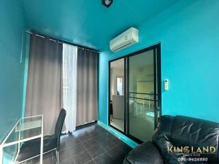 Living room with blue walls, air conditioner, glass door, and furniture