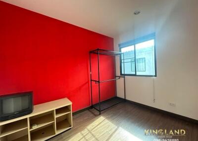 Minimalist bedroom with red accent wall