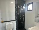 Modern bathroom with shower, toilet, sink, and window