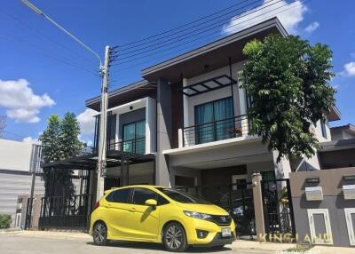 Exterior view of a modern two-story house with a yellow car parked in front