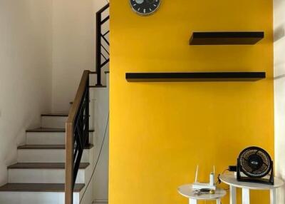 Living room with yellow accent wall and staircase