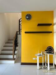 Living room with yellow accent wall and staircase