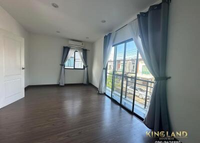 Spacious bedroom with large windows and balcony access.