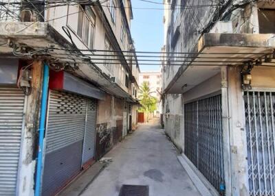 A narrow alley between two old buildings with visible utility wires.