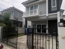 Modern two-story house with a gated driveway