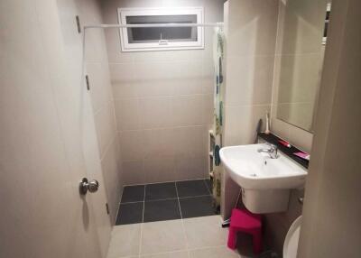 Modern bathroom with toilet, sink, and shower area