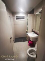 Modern bathroom with toilet, sink, and shower area