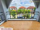 Balcony view of a residential area with houses and trees