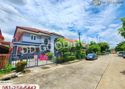 Exterior view of a residential house with a gated entrance and surrounding street