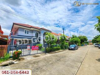 Exterior view of a residential house with a gated entrance and surrounding street