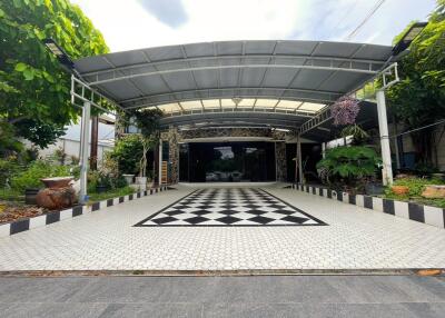 Covered outdoor area with a tiled driveway