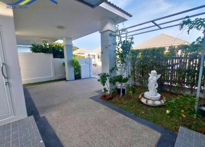 Covered patio area with garden and statue