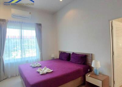 Modern bedroom with purple bedding and natural light