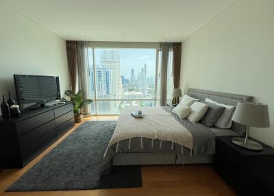 Spacious bedroom with large window and urban view