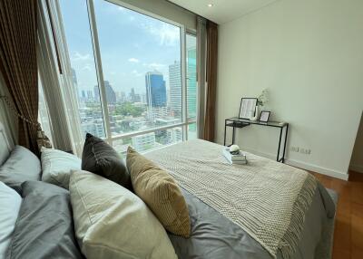 Modern bedroom with a large window and city view