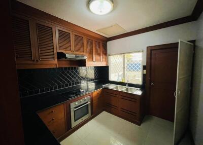 Modern kitchen with wooden cabinets and black backsplash