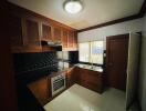 Modern kitchen with wooden cabinets and black backsplash