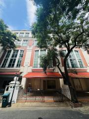 Exterior view of a multi-storey building with red awnings