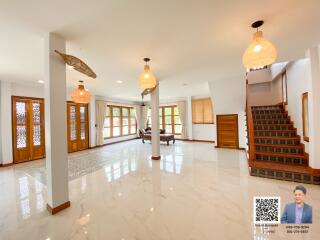 Spacious and well-lit living area with modern lighting fixtures and large windows