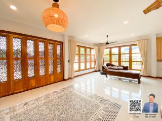 Spacious living room with large windows and wooden features