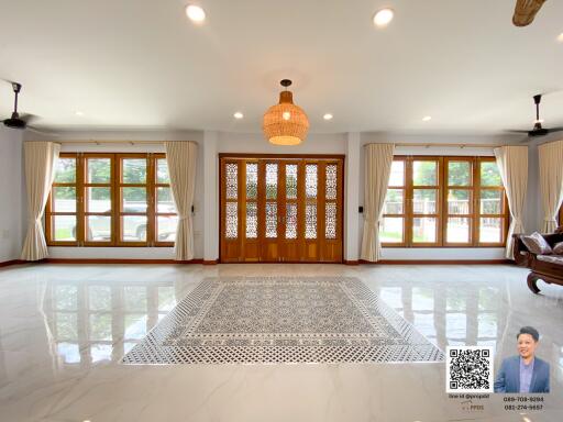 Spacious and bright living room with large windows and chandelier