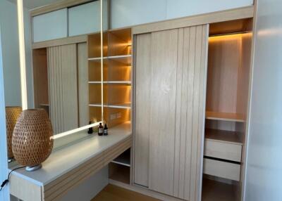 Well-lit dressing room with wooden shelves and vanity table