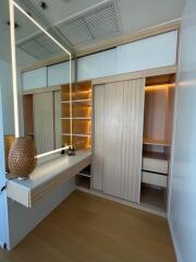 Well-lit dressing room with wooden shelves and vanity table