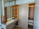 Well-lit dressing room with wooden shelves and vanity table