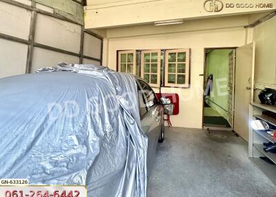 Covered car parked in a garage with storage space