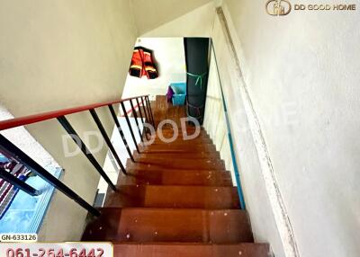 Wooden staircase with red railings and landing area