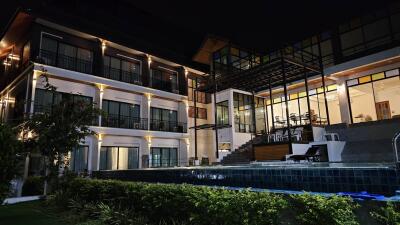 Exterior view of a modern multi-story building with pool at night