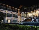 Exterior view of a modern multi-story building with pool at night