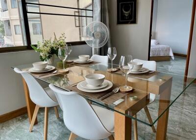 Dining area setup with a glass table and white chairs