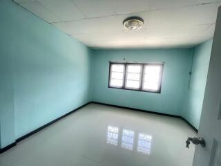 Empty bedroom with blue walls and a window