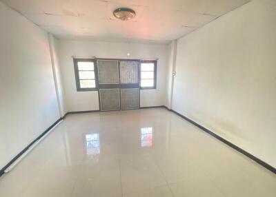 Bright empty living room with tiled floor and large windows