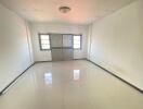 Bright empty living room with tiled floor and large windows