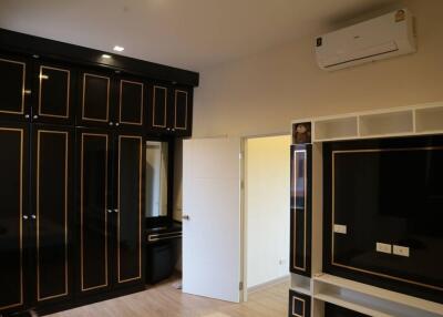 Spacious bedroom with large wardrobe and wall-mounted air conditioning