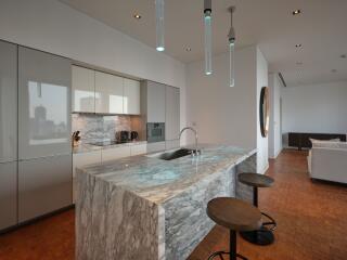 Modern kitchen with marble island and hanging lights