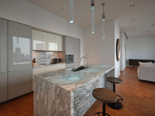 Modern kitchen with marble island and hanging lights