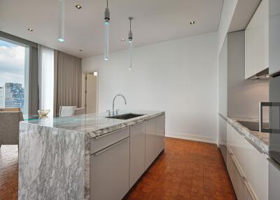 Modern kitchen with marble island and view of dining area