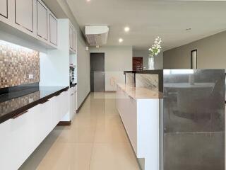 Modern kitchen with marble countertops and tiled backsplash