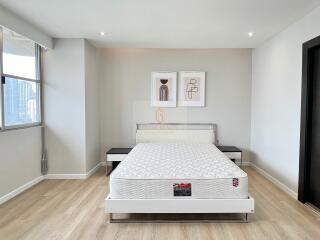 Modern bedroom with a bed and artwork on the wall