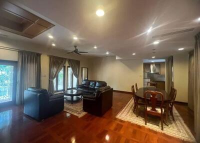 Spacious living room with leather sofas, wooden floor, and dining area