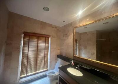 Well-lit bathroom with large mirror and window