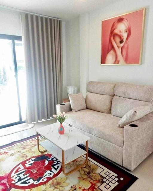 A modern living room with a sofa, coffee table, and wall painting