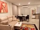 Modern living room featuring a comfortable sofa, wall art, a dining area with six chairs, an air conditioning unit, and decorative accents.