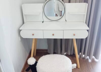 Vanity table with mirror and stool in a bedroom