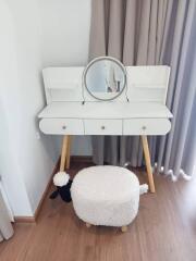 Vanity table with mirror and stool in a bedroom