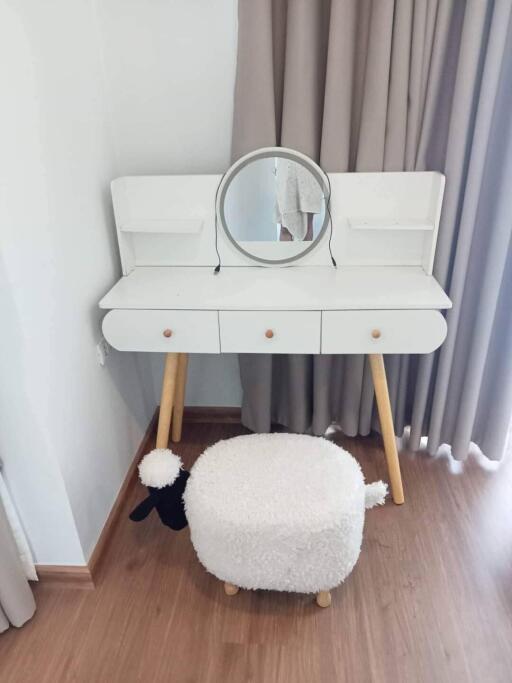 Vanity table with mirror and stool in a bedroom